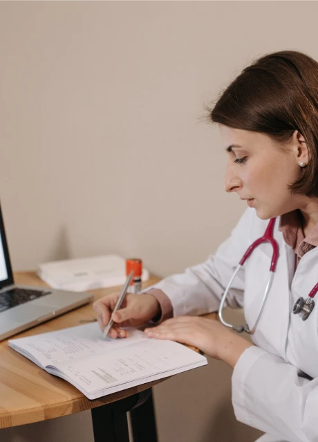 Healthcare professional reviewing information and writing something in the notepad