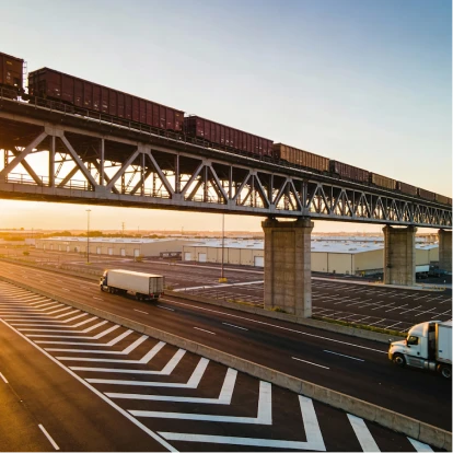 Freight train and trucks transporting goods through a logistics facility