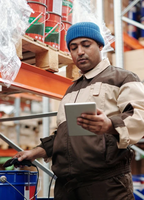 Warehouse worker using a tablet and scanner to manage inventory