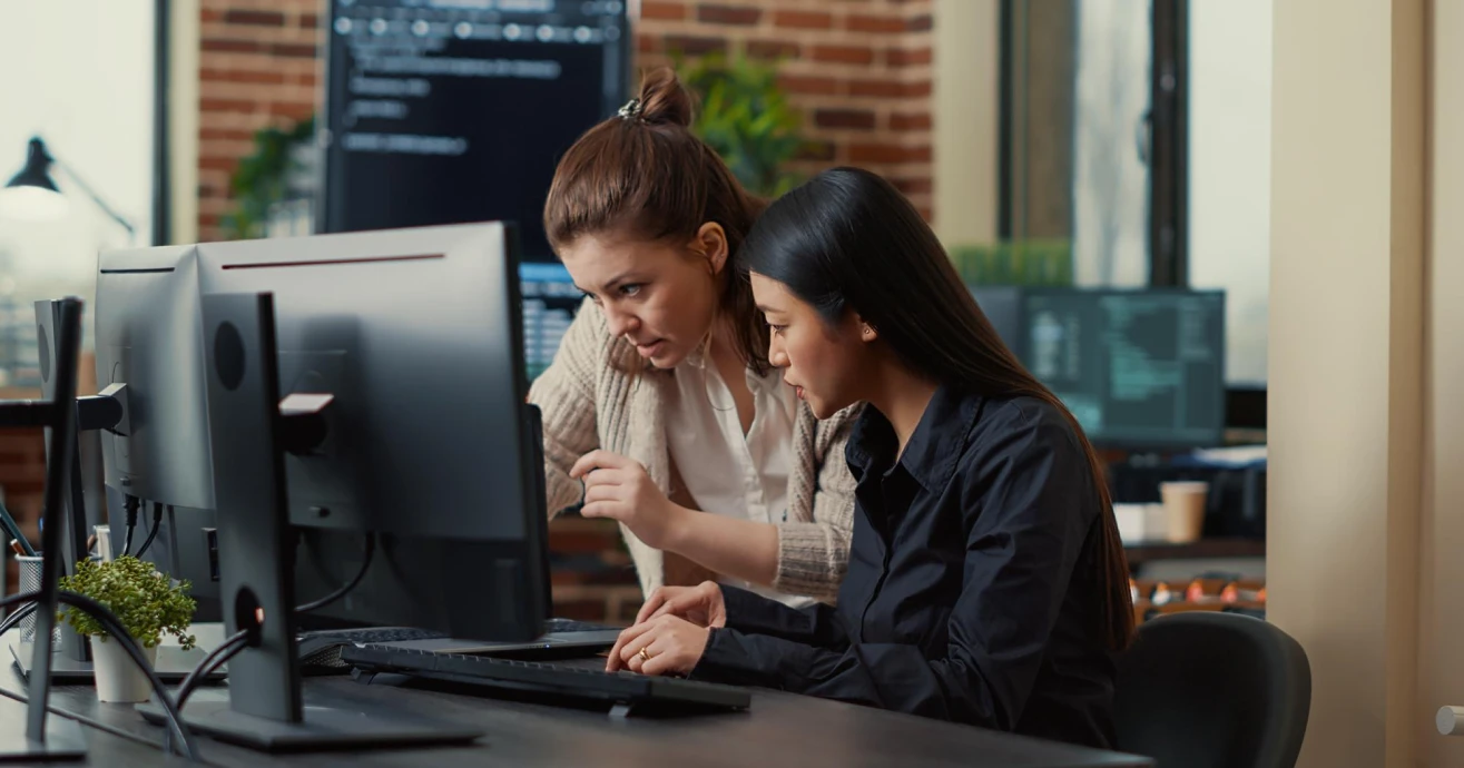Developers collaborating at computers in an office