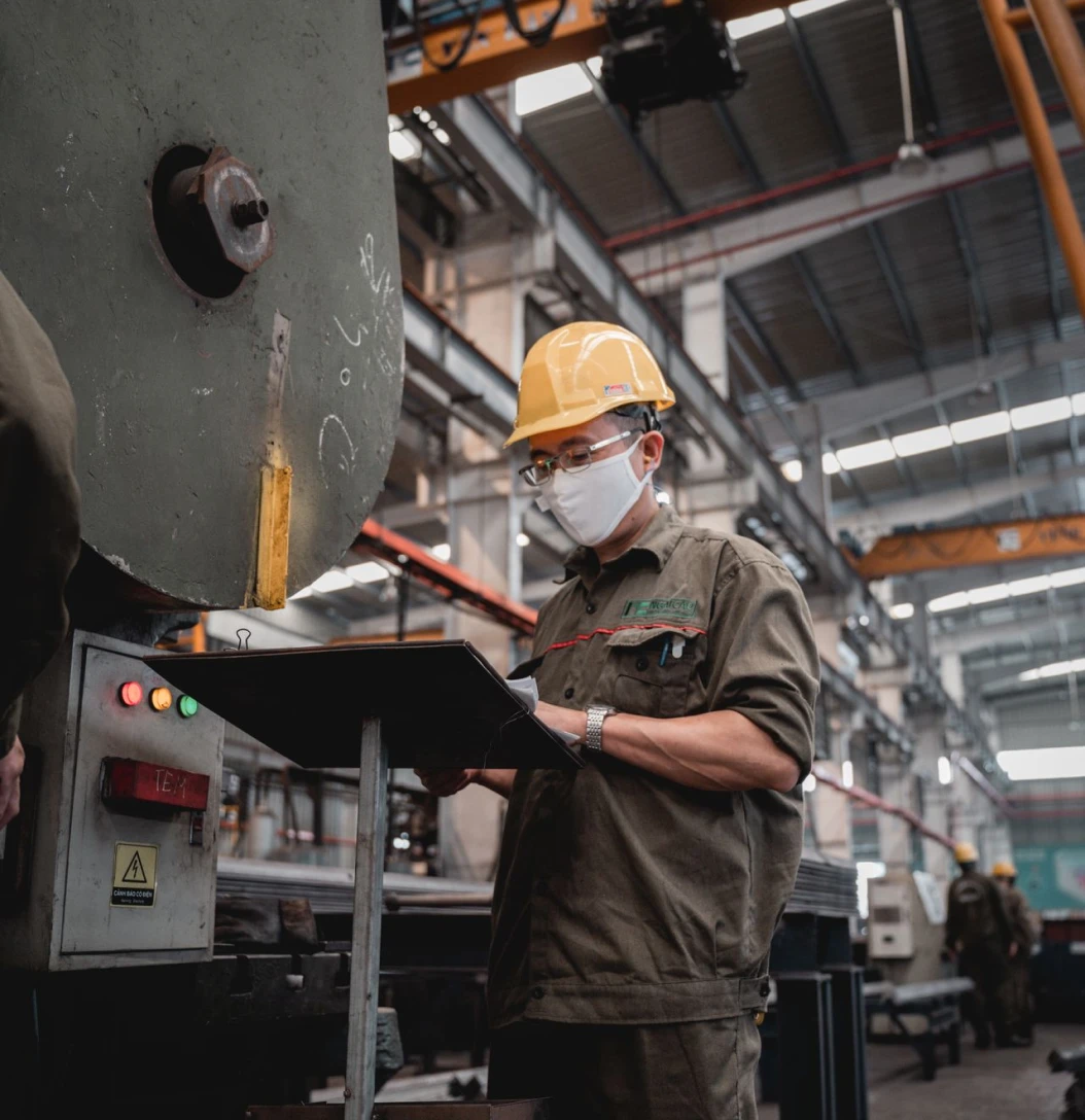 Worker operating industrial machinery in a manufacturing facility