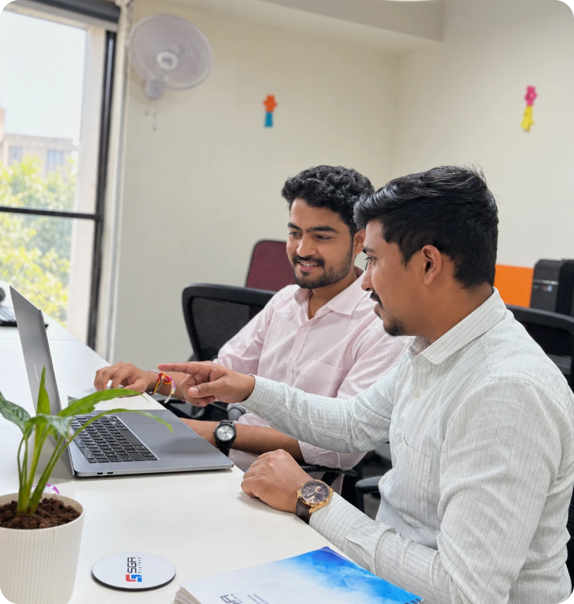 Software team members working on laptop in an office
